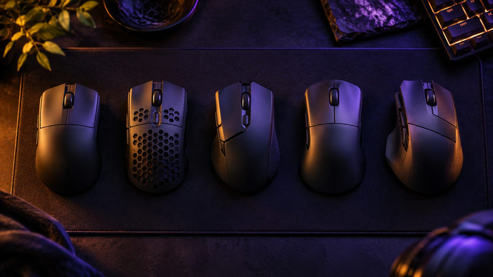 Five gaming mice of different shapes laid out for comparison