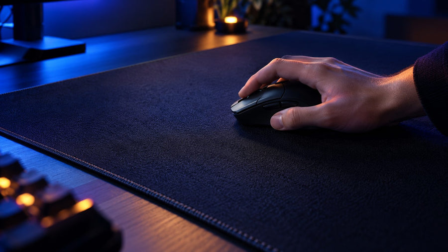 Large stitched mouse pad with gaming mouse and hand