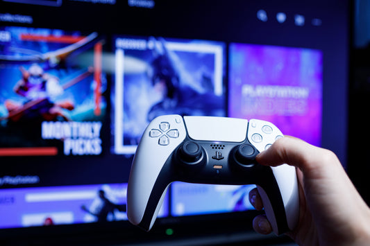 Hand holding a gaming controller in front of a television screen displaying a sports broadcast.